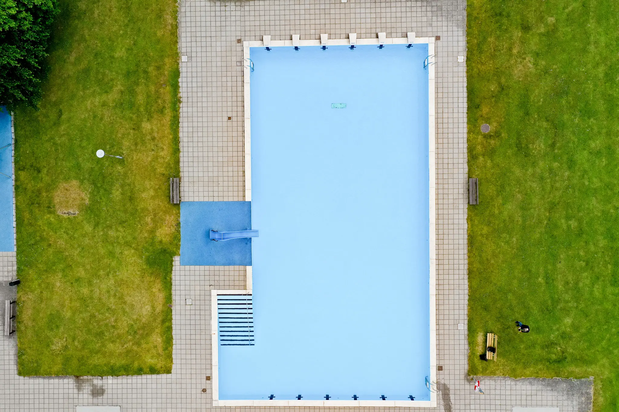 Flygbild över friluftsbadet i Skurup, pool och gräsmatta.