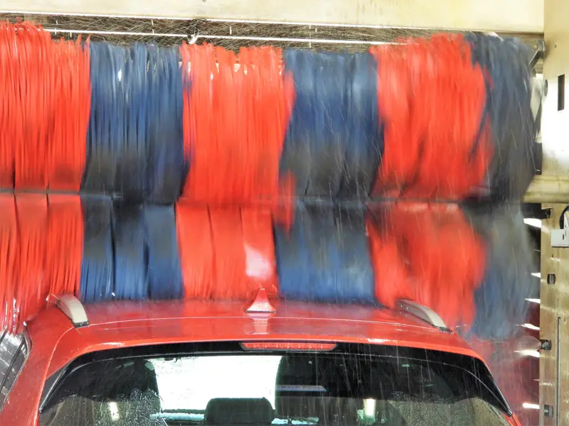 Bil som tvättas i automatisk biltvätt.