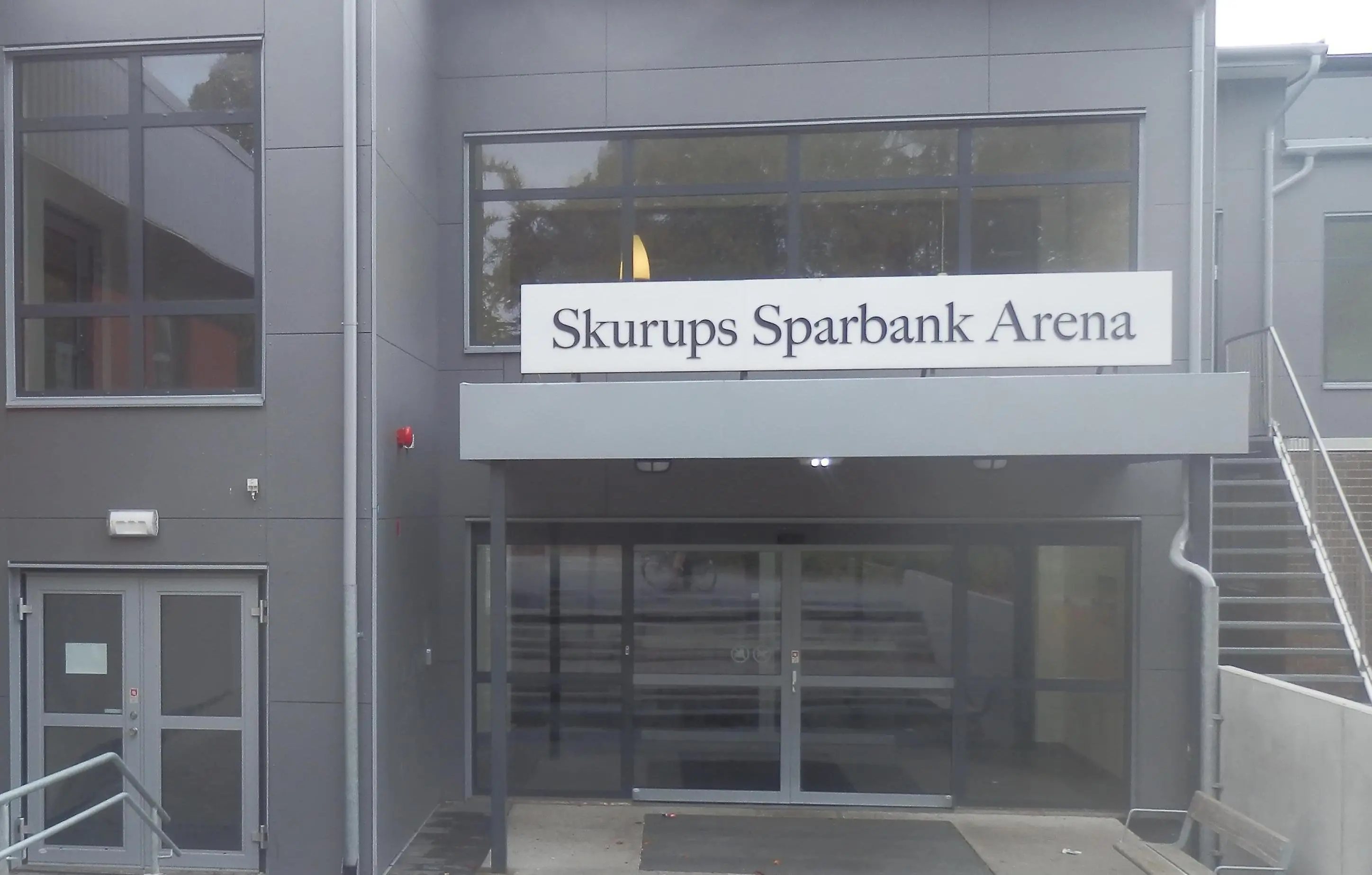 Fasad, dörr, fönster, skylt med texten Skurups sparbank arena.
